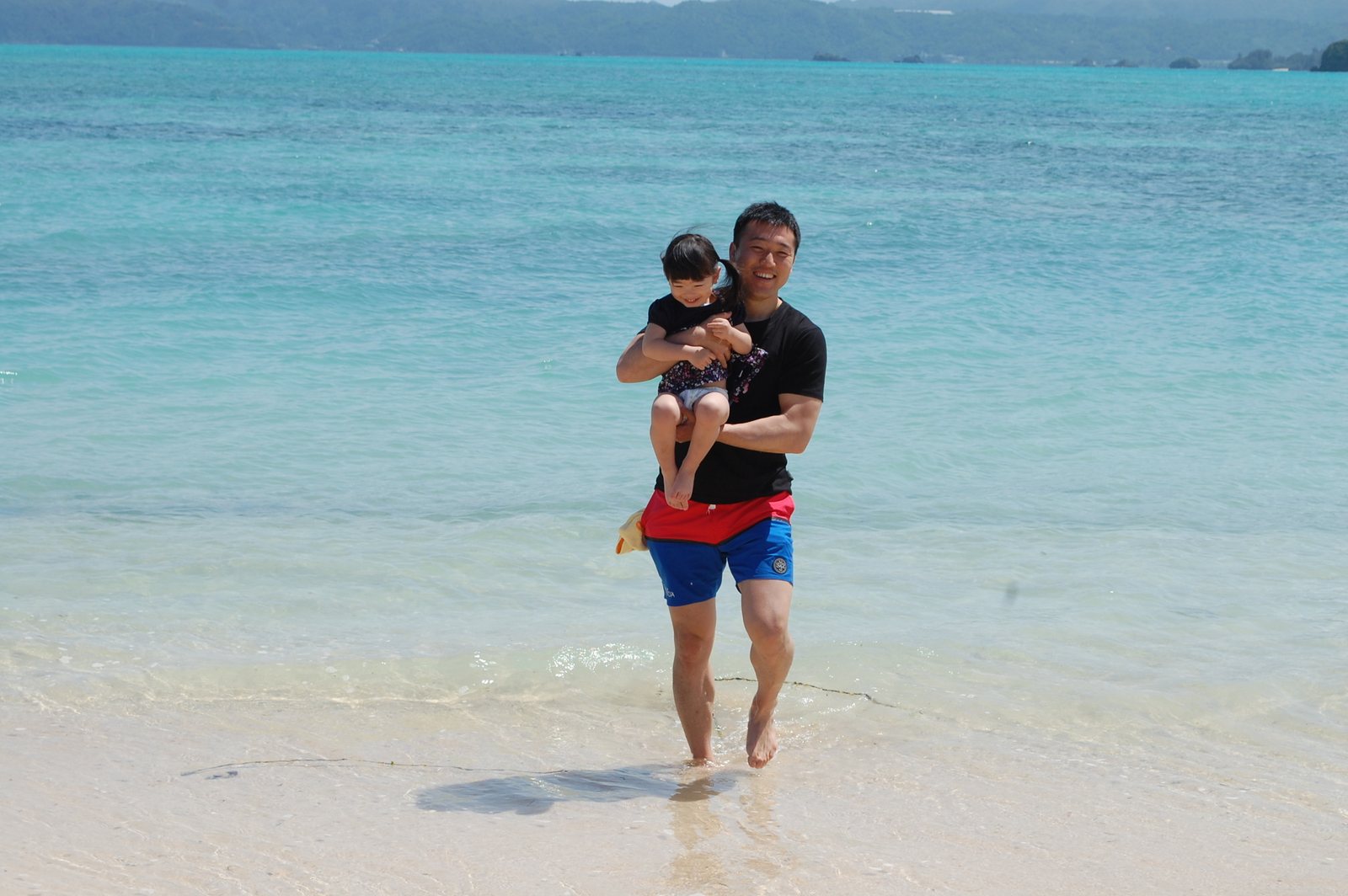 海辺で子どもを抱える湯上裕盛